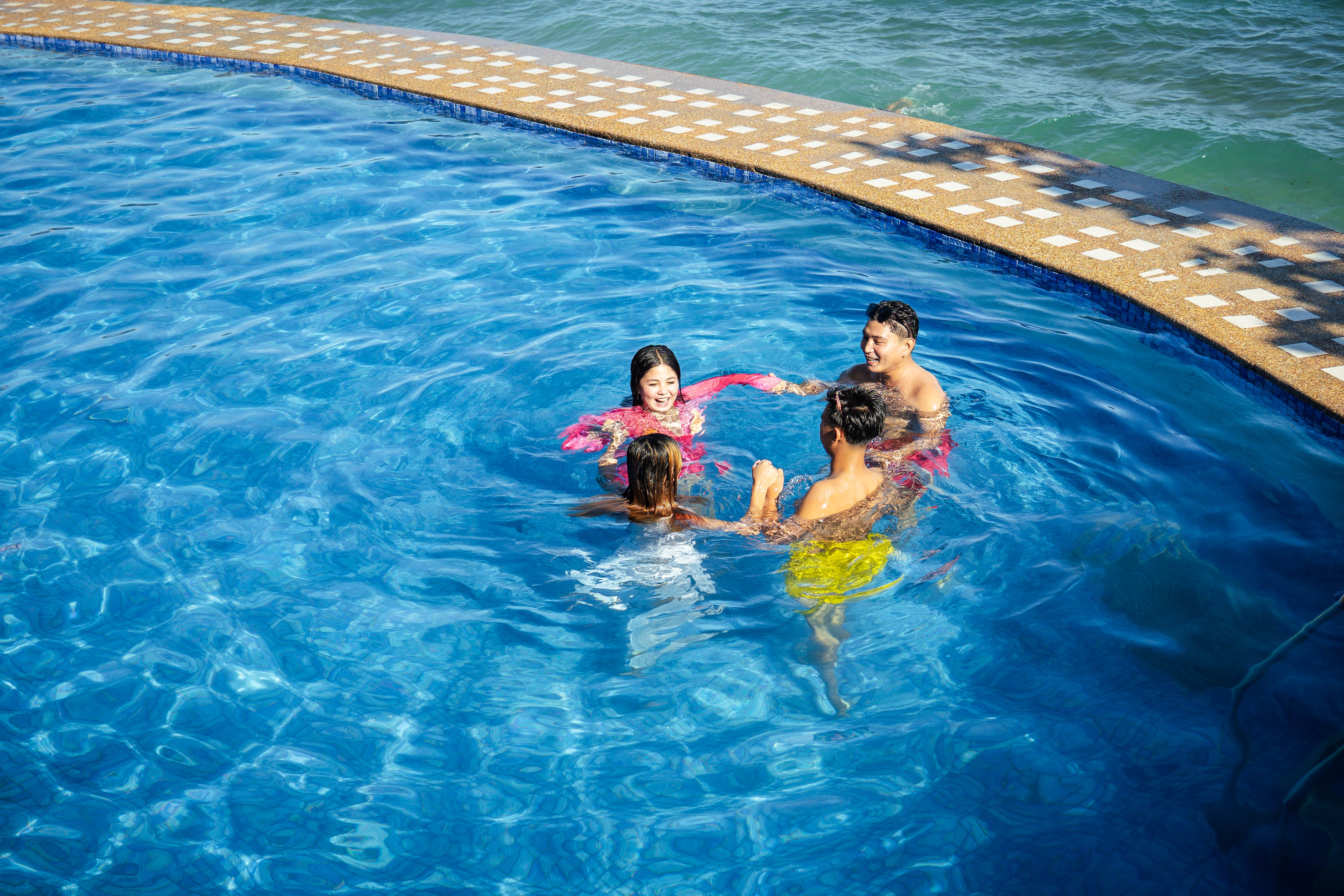 Friends having fun in the swimming pool at Brizamar Beach Resort Batangas City Philippines