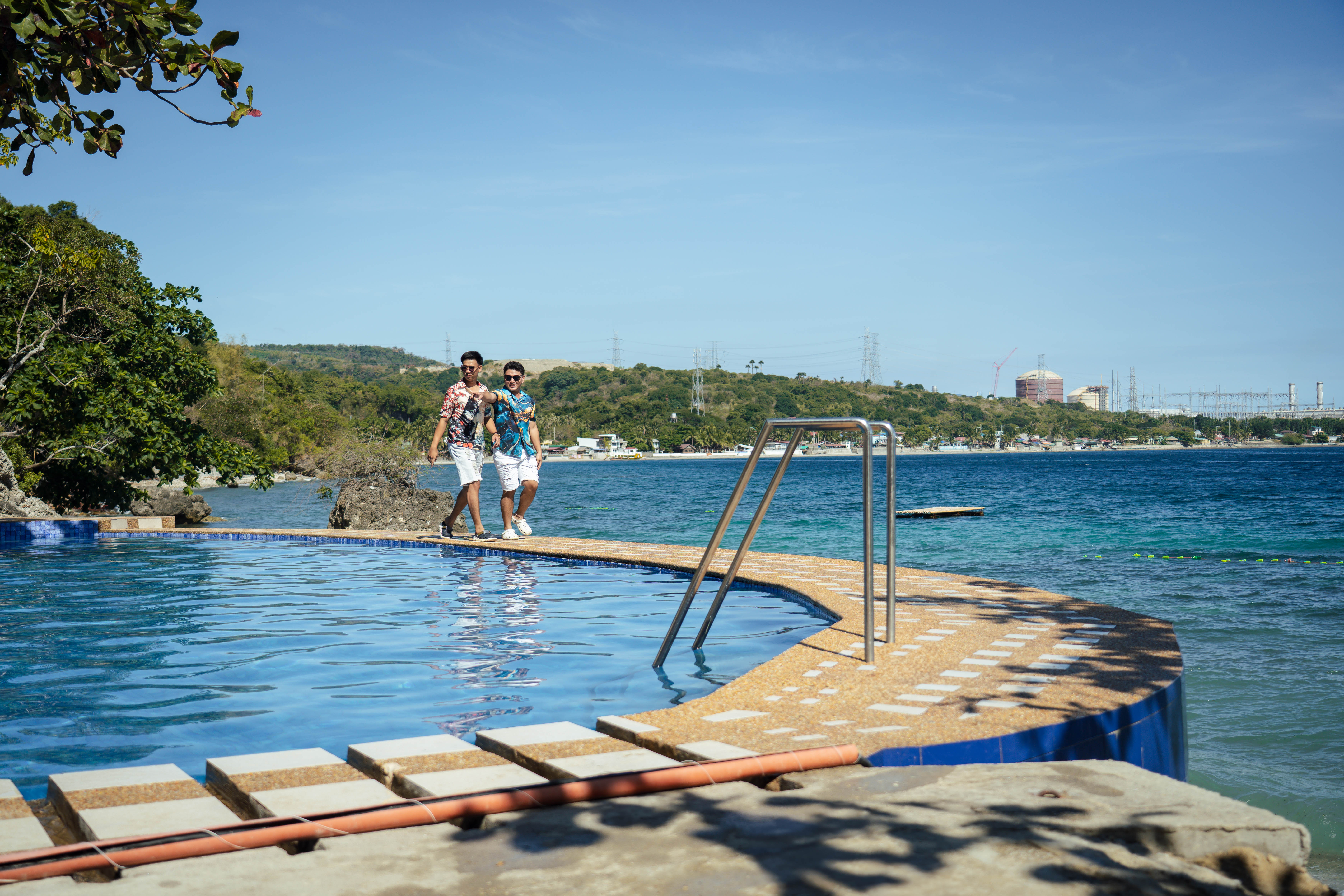 Guests at the infinity pool edge overlooking the ocean at Brizamar Beach Resort Batangas